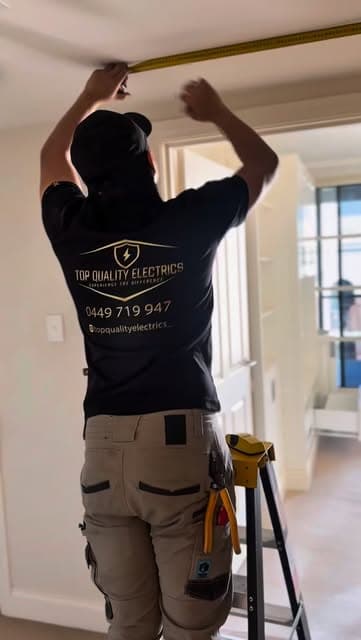 Top Quality Electrics electrician measuring a ceiling inside a home